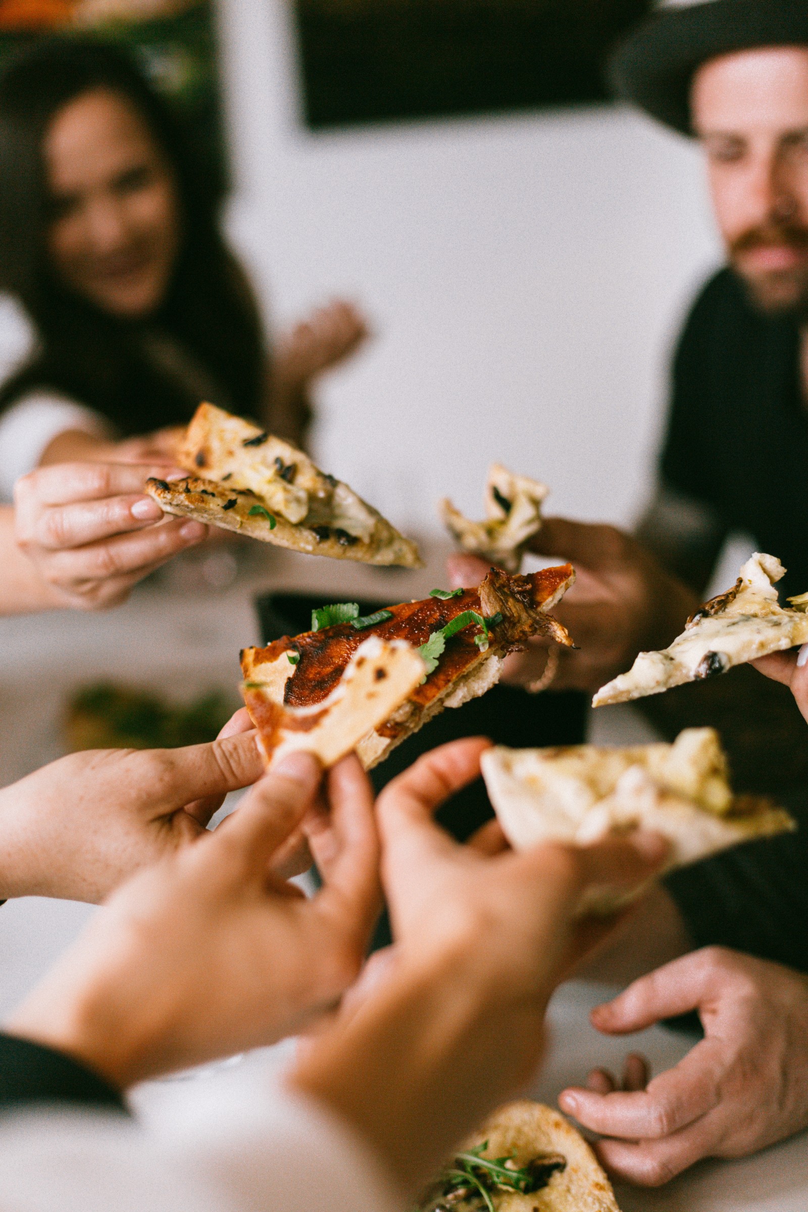 People sharing slices of pizza